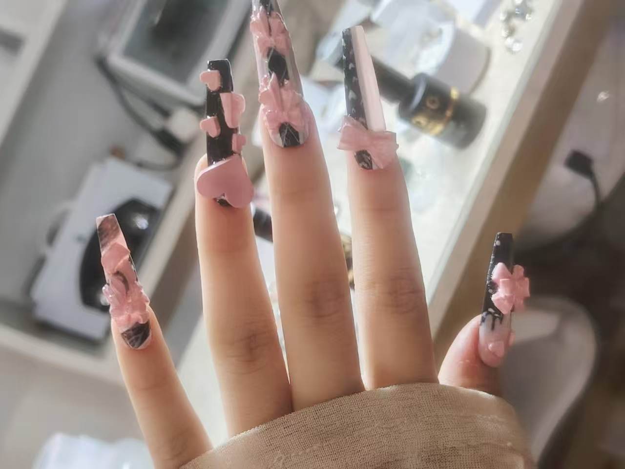 Nail art nera con fiocchi rosa 3D